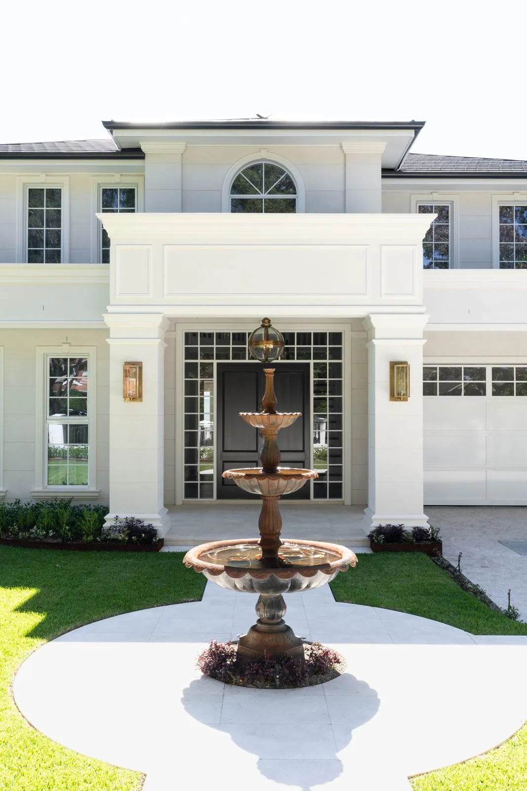 Tiered fountain in a circular stone forecourt in front of a classic Turramurra home
