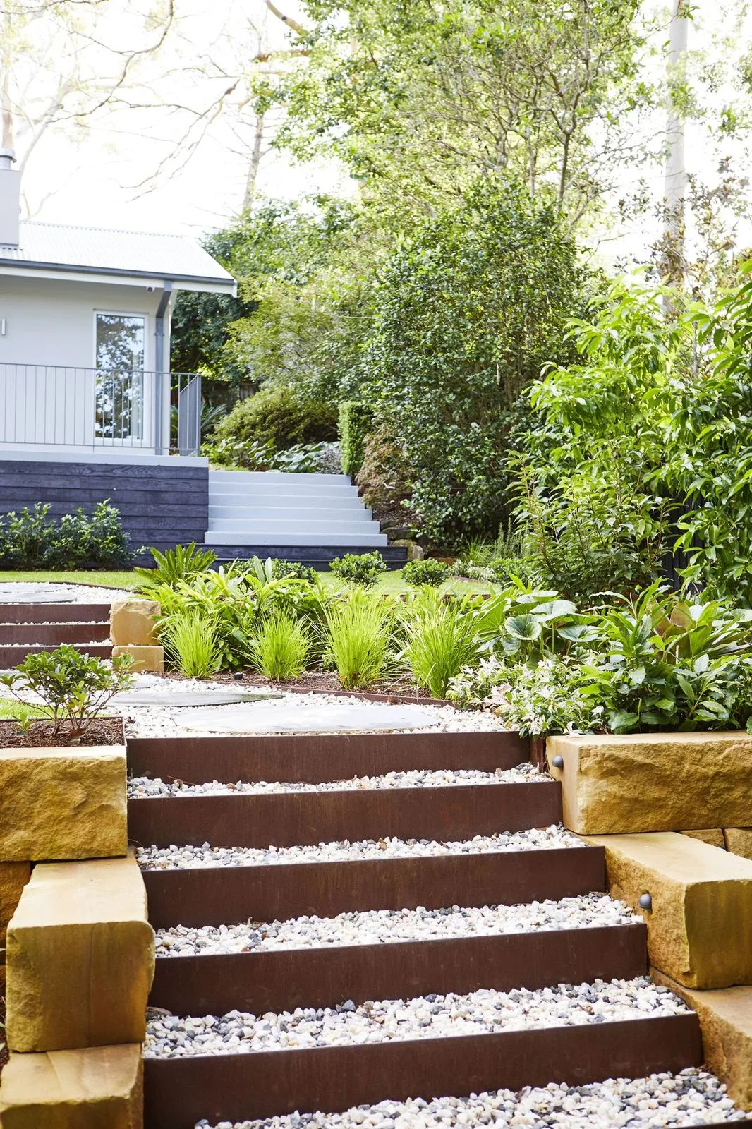 Sandstone block stairs with gravel treads leading through the garden
