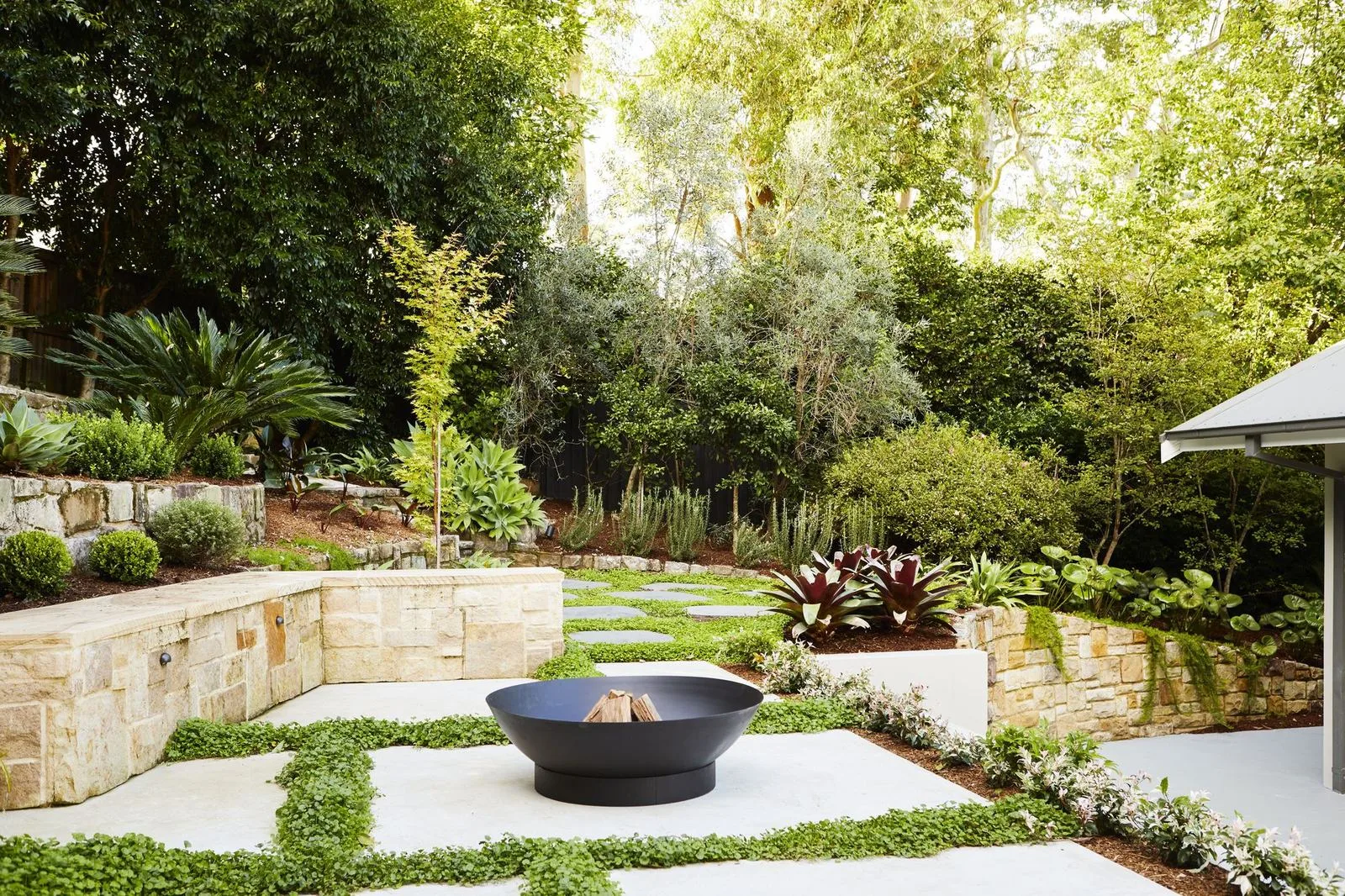 Fire pit courtyard with large pavers and green groundcover joints, Pymble